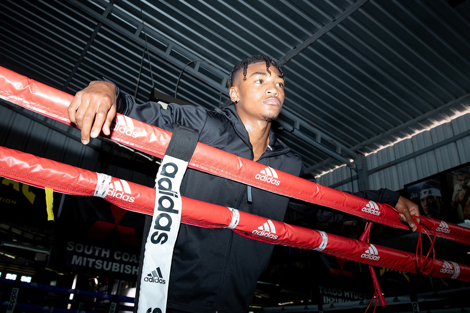 A man standing in a boxing ring, displaying Adidas Boxing Ring Rope Separators.