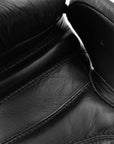 Close-up of a black boxing glove, showing design details.