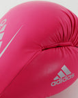 Pink boxing glove with silver adidas logo in close view.