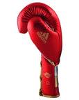 Red boxing glove with gold trim from adidas Adi-Speed 501 series, designed for professional use.