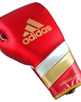 Red boxing glove with gold stripes, adidas Adi-Speed 500 Pro.