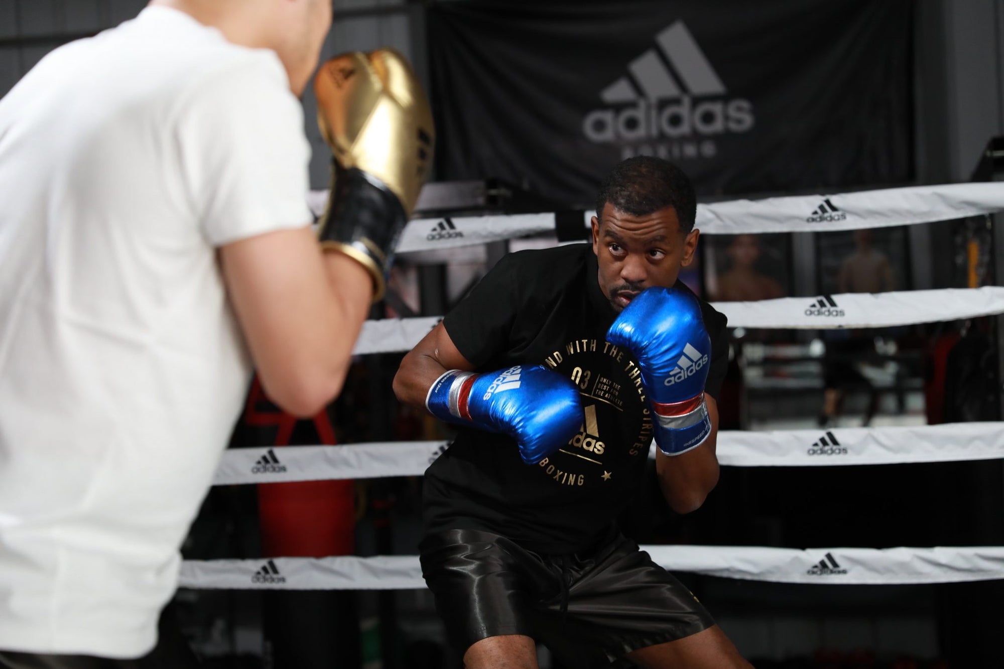 A man wearing boxing gloves inside a ring.