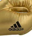 Close-up of gold Adidas boxing glove with logo detail.