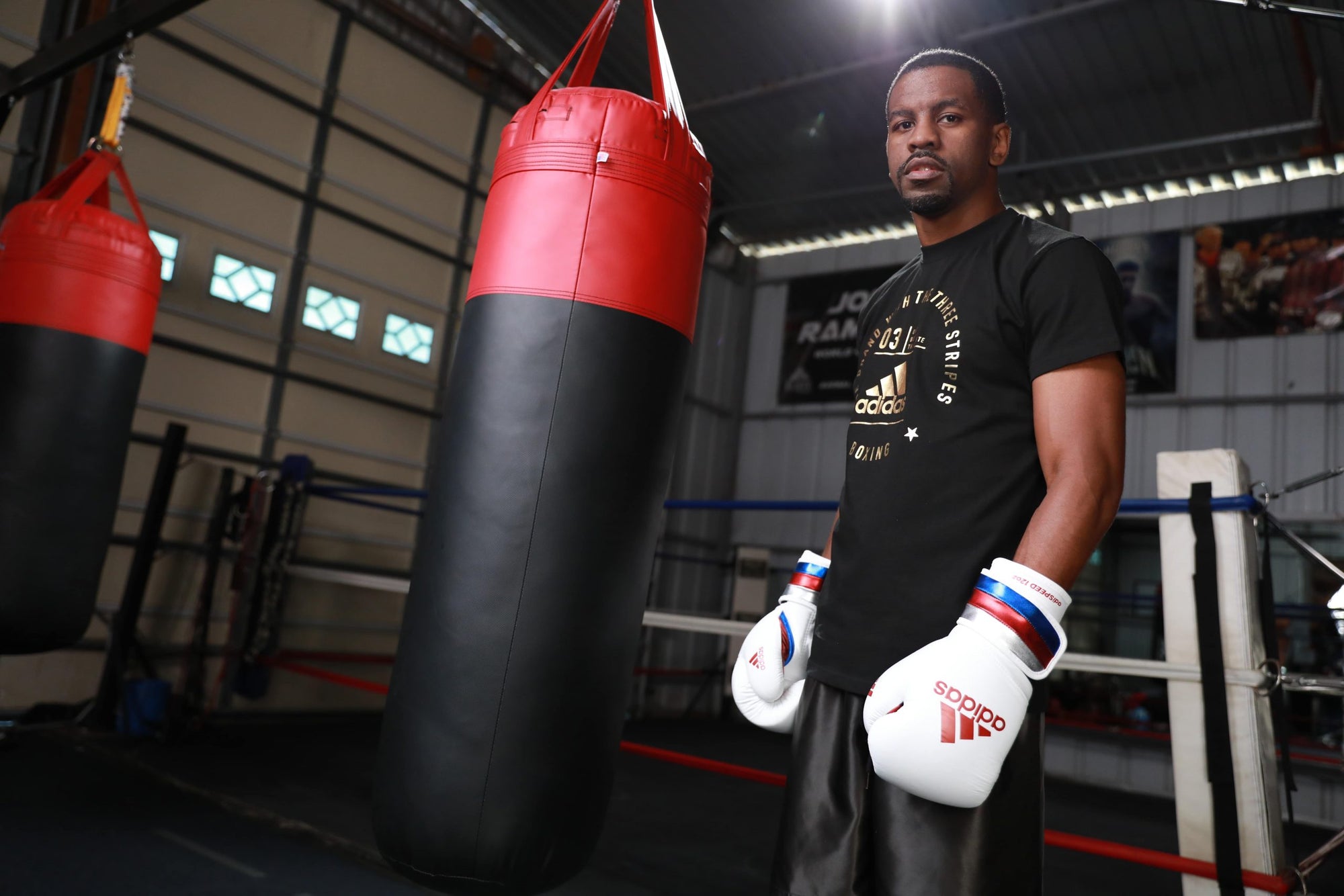 Man wearing boxing gloves holding a punching bag.