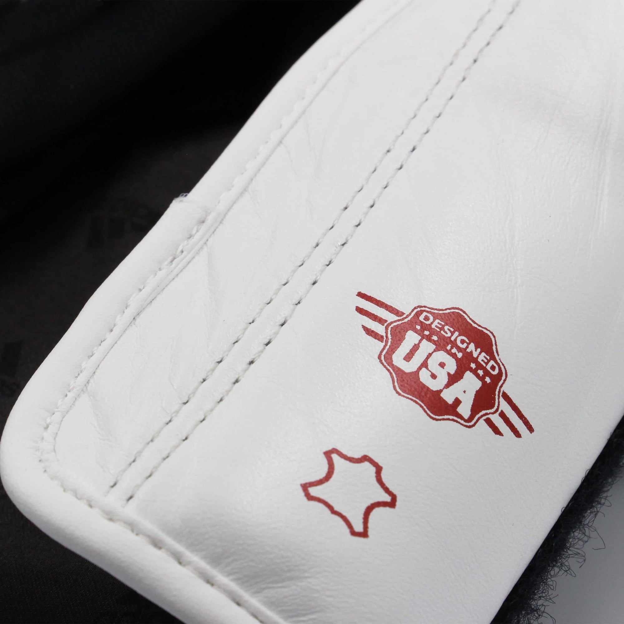 White leather boxing glove with red logo.