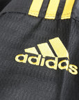 Close-up of black and yellow Adidas logo on uniform.