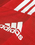 Red shirt close-up with focus on shoulder logo.