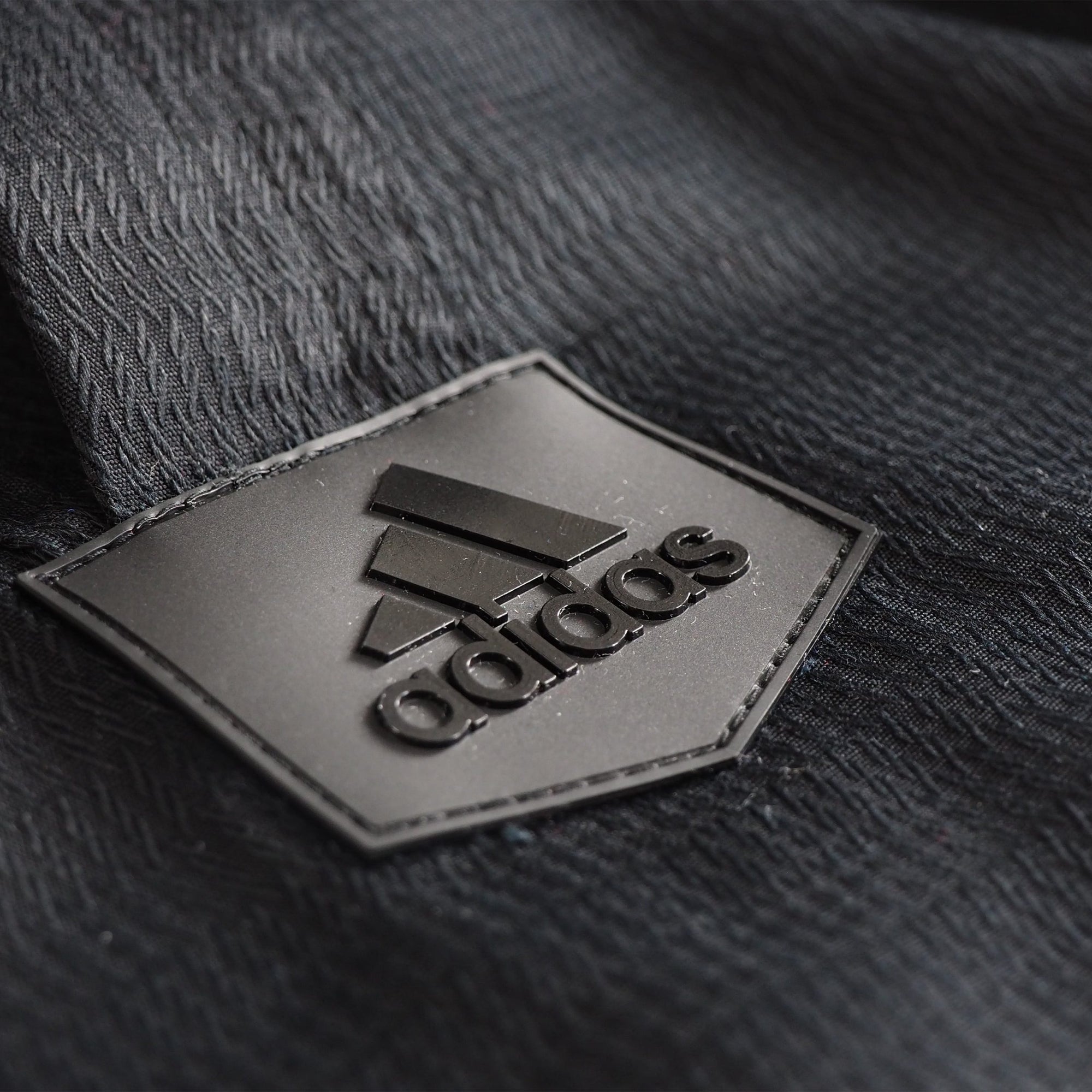 Black logo patch on black fabric from Adidas uniform.