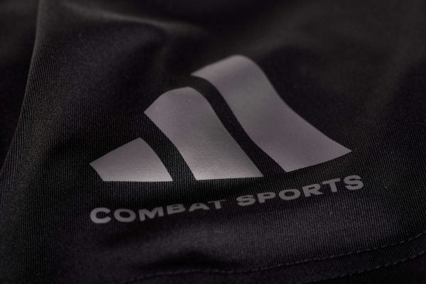 Close-up of logo on black performance shirt.