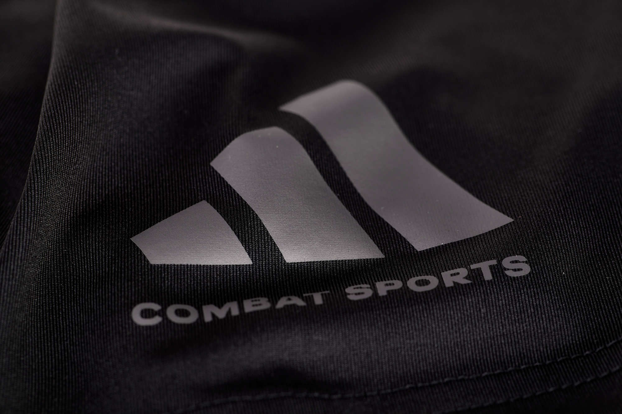 Close-up of Adidas logo on combat sports drifit T-shirt.