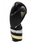 Black and gold adidas boxing glove, 14 oz, for men and women.