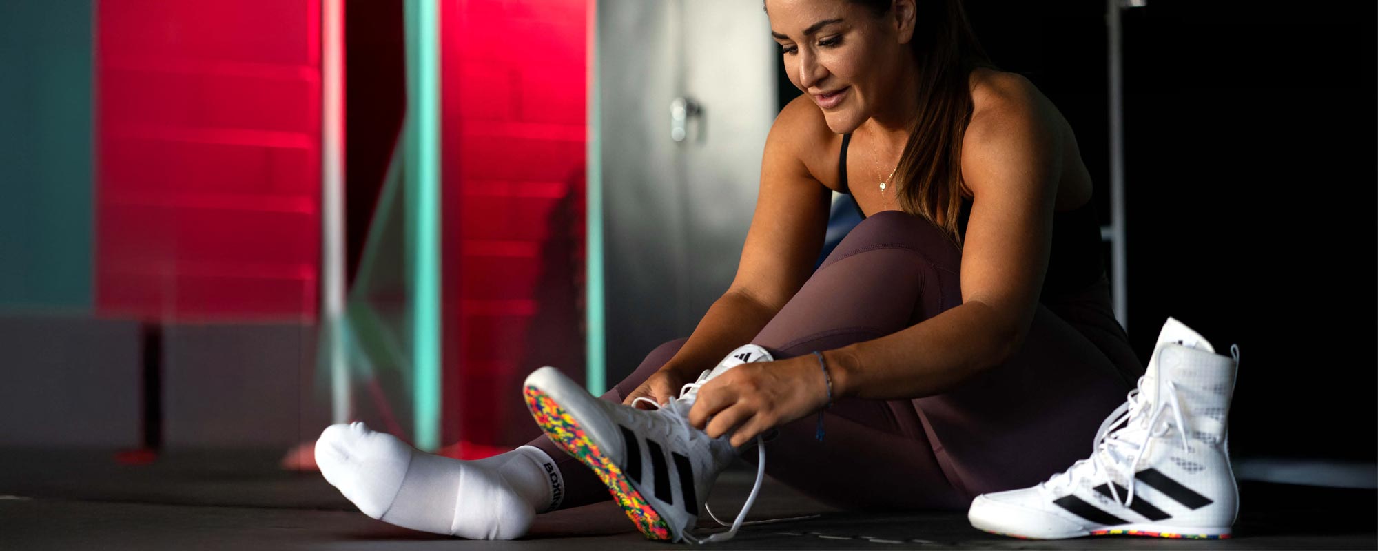 Woman putting on adidas boxing shoe