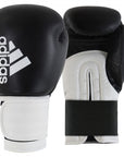 A pair of boxing gloves, Adidas Hybrid 100, in black and gold, 12 oz weight.