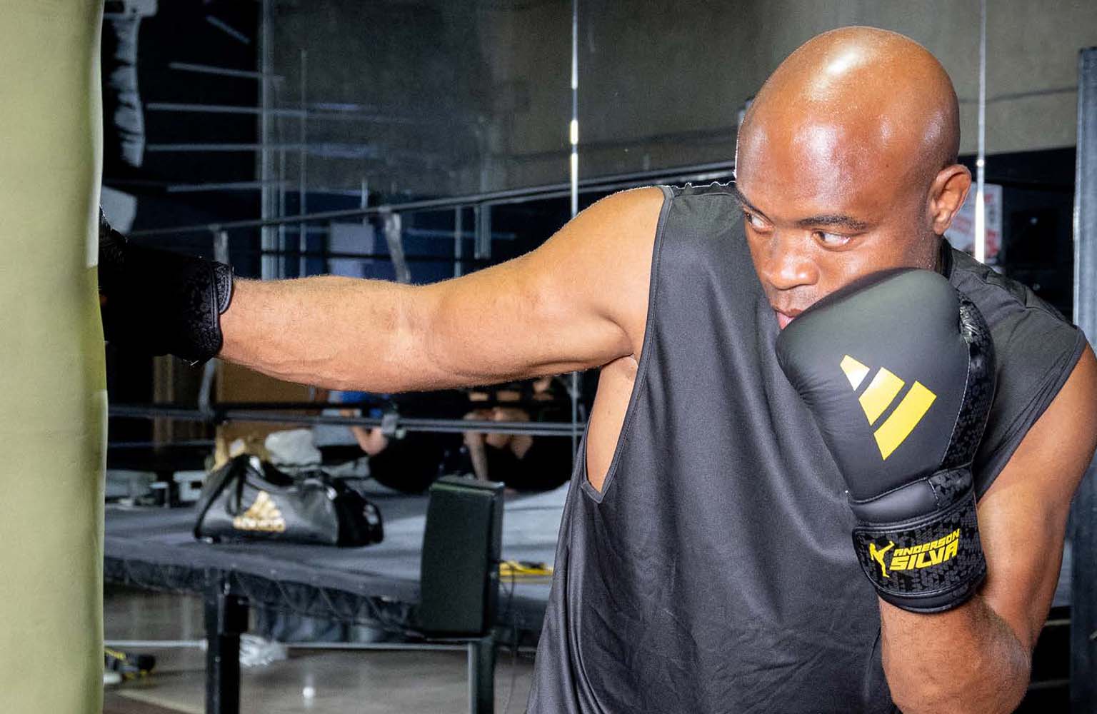 Man wearing Adidas x Anderson Silva boxing gloves.