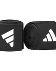 A pair of black wrist wraps for boxing with stretchable tape.