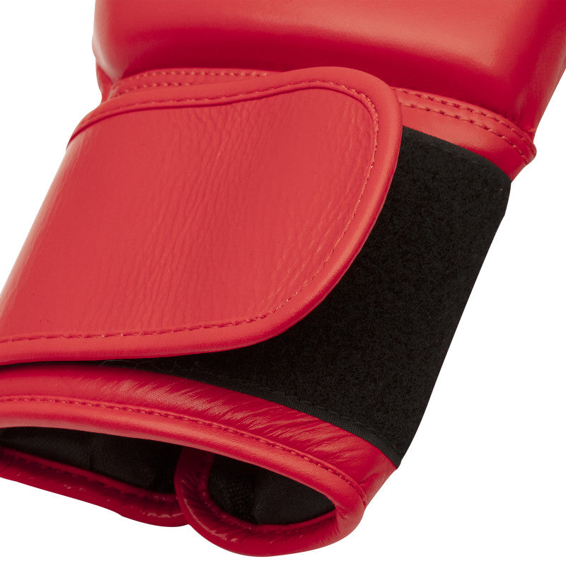 Red boxing glove with black straps, side view.