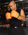 A man wearing adiSPEED 501 PRO boxing gloves.