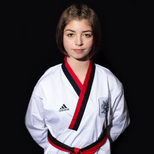 Girl wearing Adidas Poomsae taekwondo uniform in white and red.