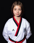 Girl wearing Adidas Poomsae taekwondo uniform in white and red.