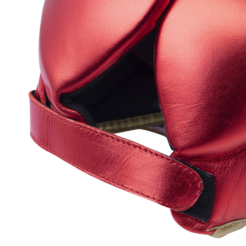 Red boxing helmet with strap designed for protection.