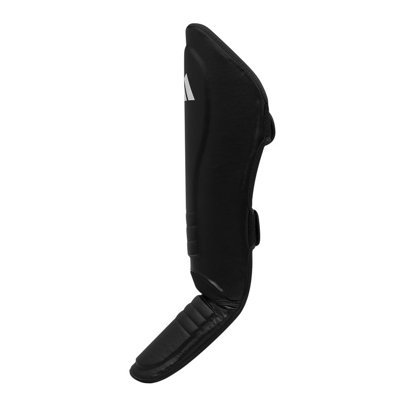 Black shin guard on white background, suitable for boxing.