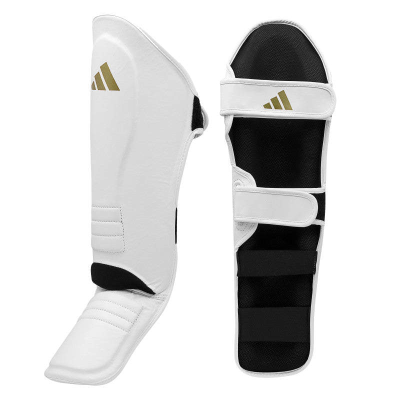 White shin guard with black straps for boxing.