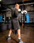 A man in a gym wearing boxing gloves.