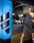 A man in boxing gloves punching a punching bag.