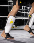 Person wearing black and yellow shin guards.