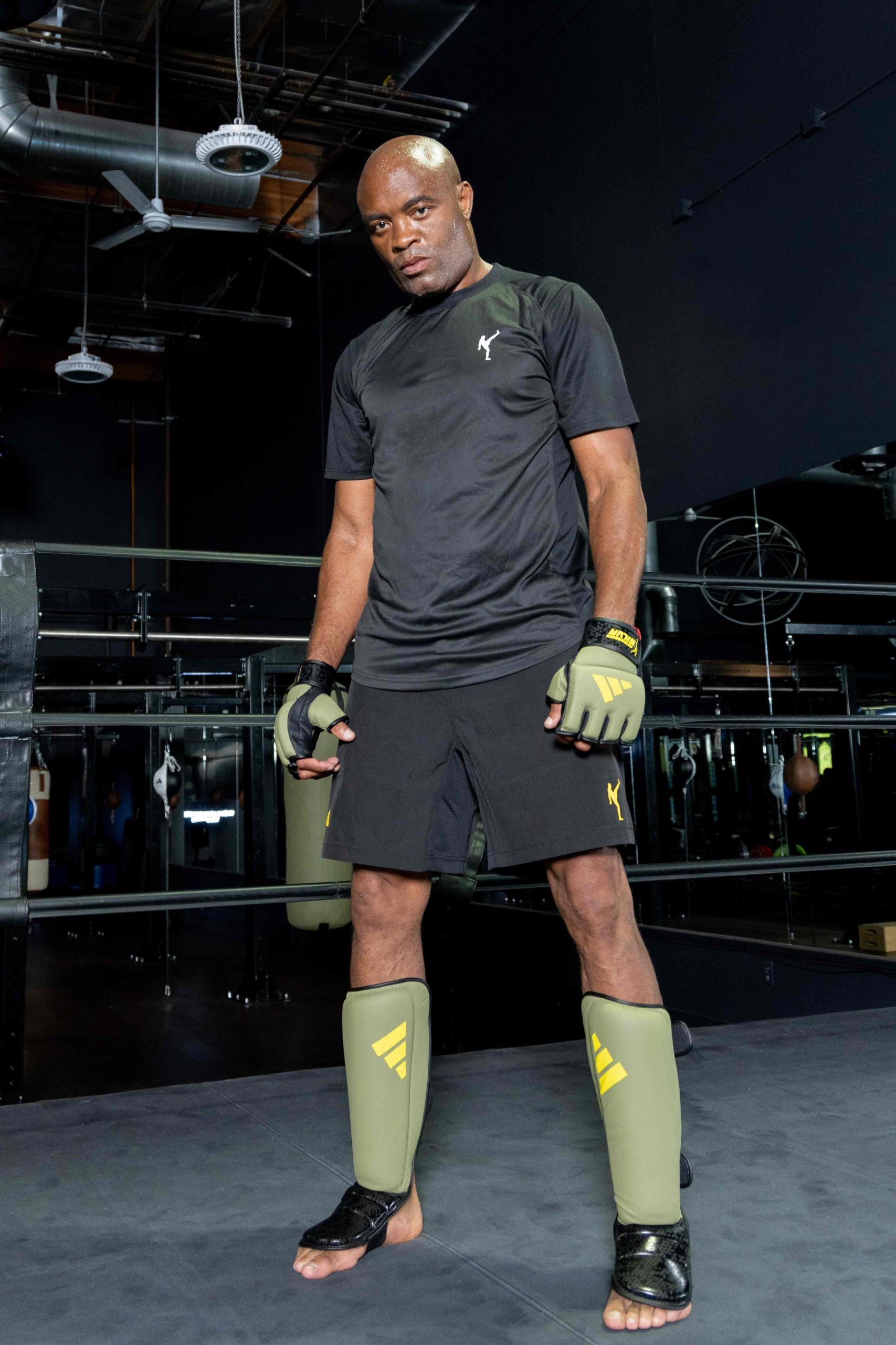 Man wearing gloves and shorts in boxing ring.