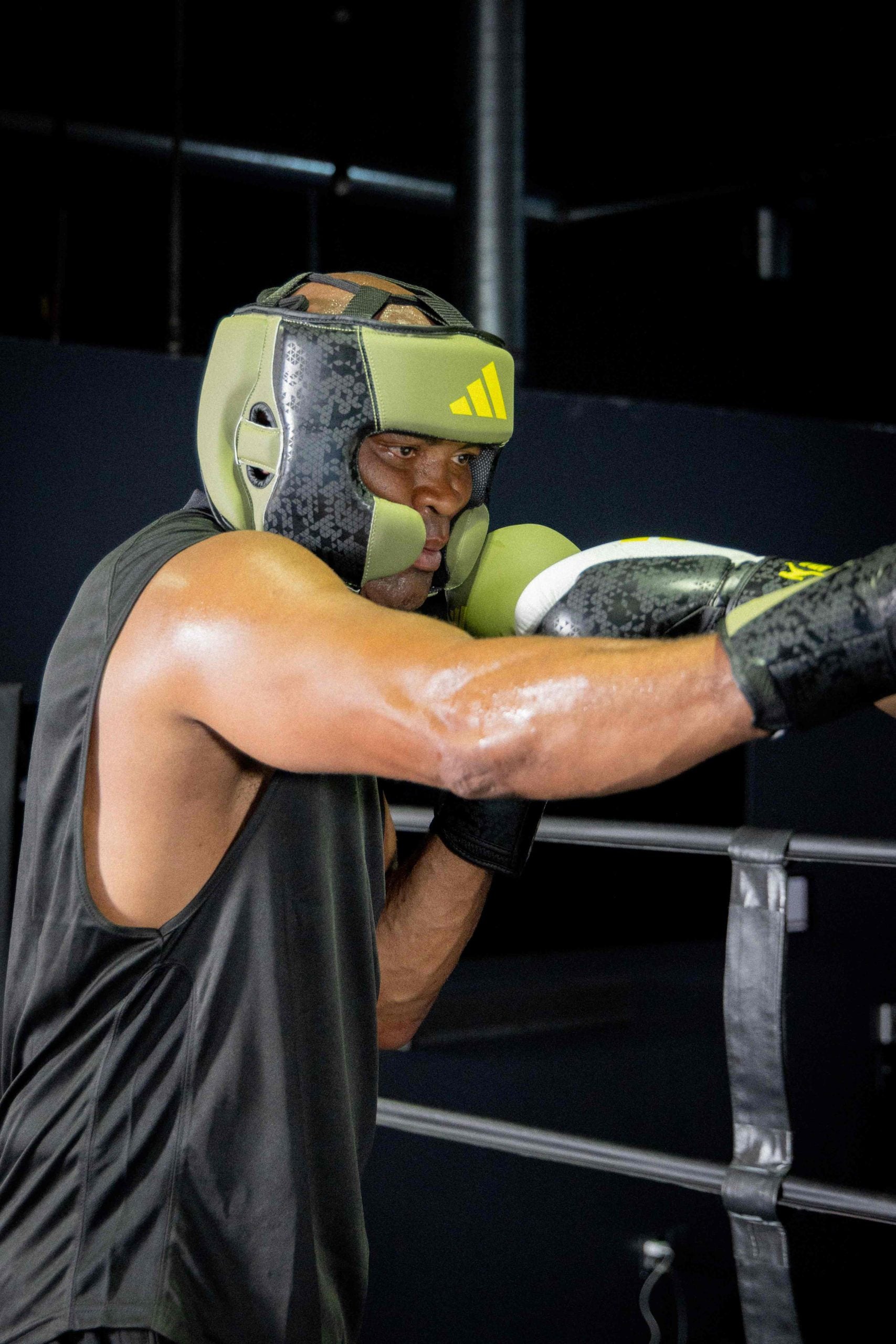 A man wearing boxing gloves and helmet poses for a photo.