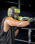 A man wearing boxing gloves and helmet poses for a photo.