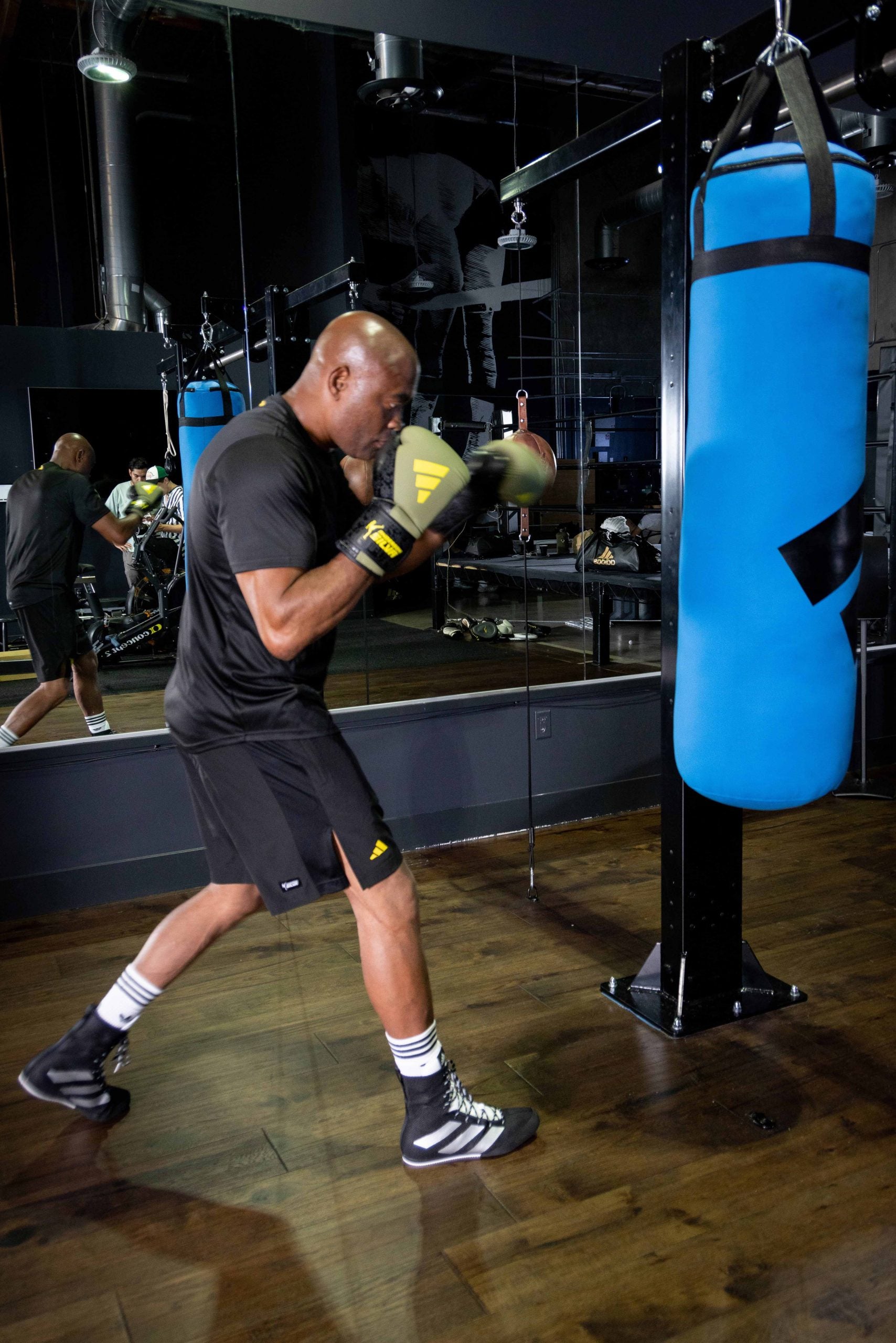 A man in boxing gloves in a gym.