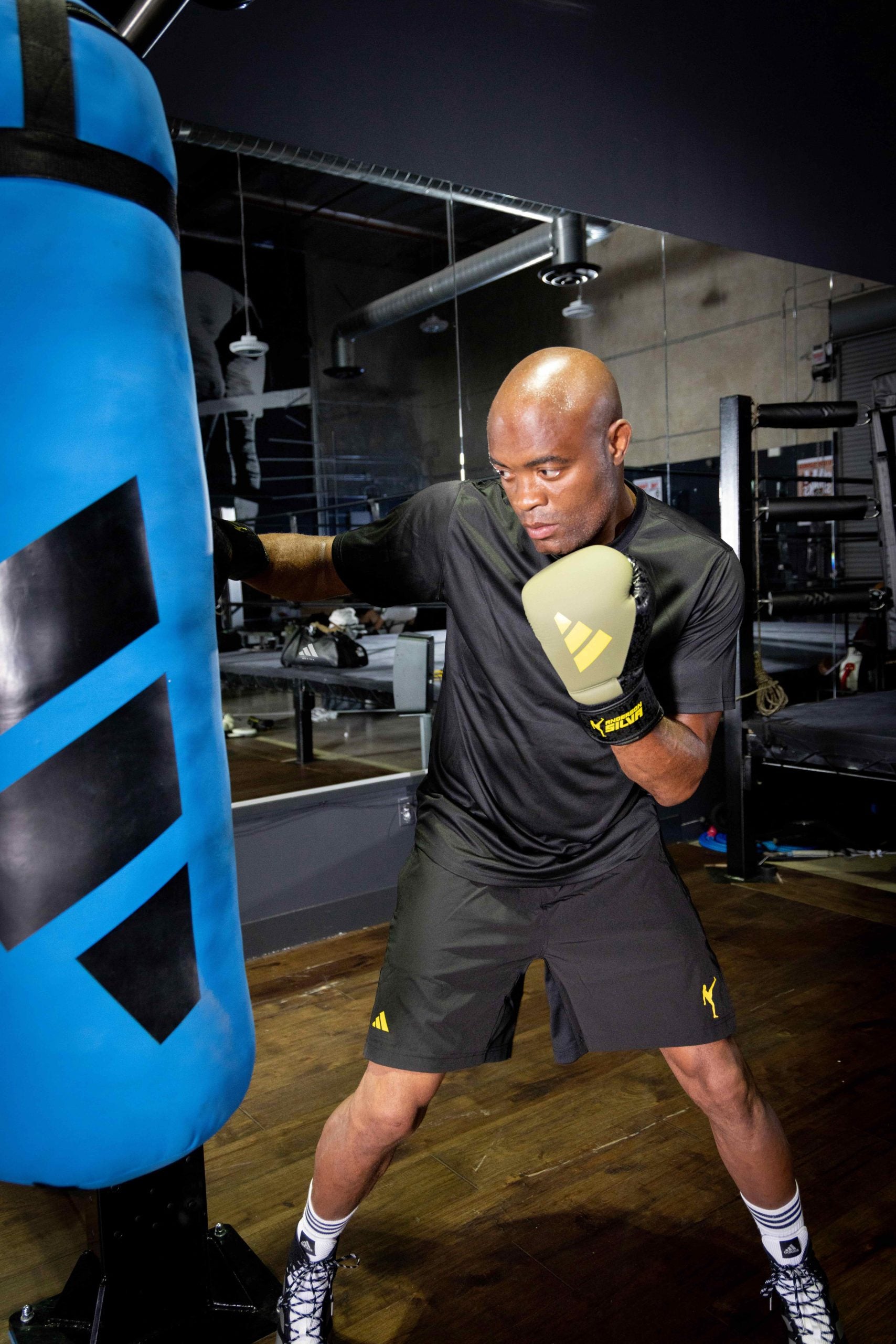 A man wearing boxing gloves and punching bag.