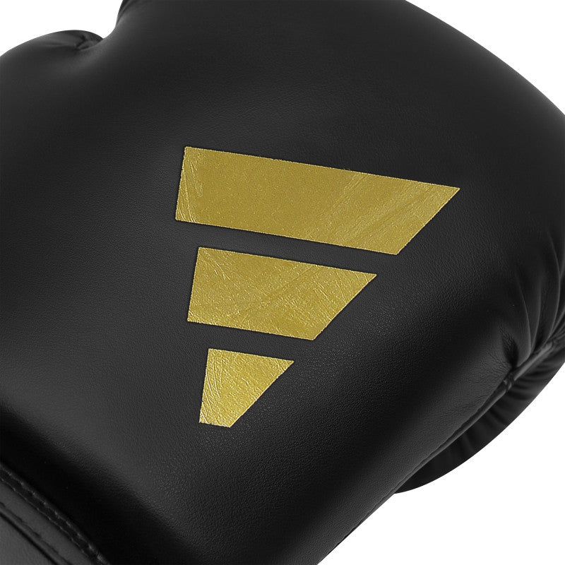 Black boxing glove with a gold logo on it.