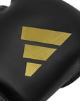 Black boxing glove with a gold logo on it.