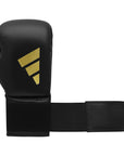 A black boxing glove with a black strap.