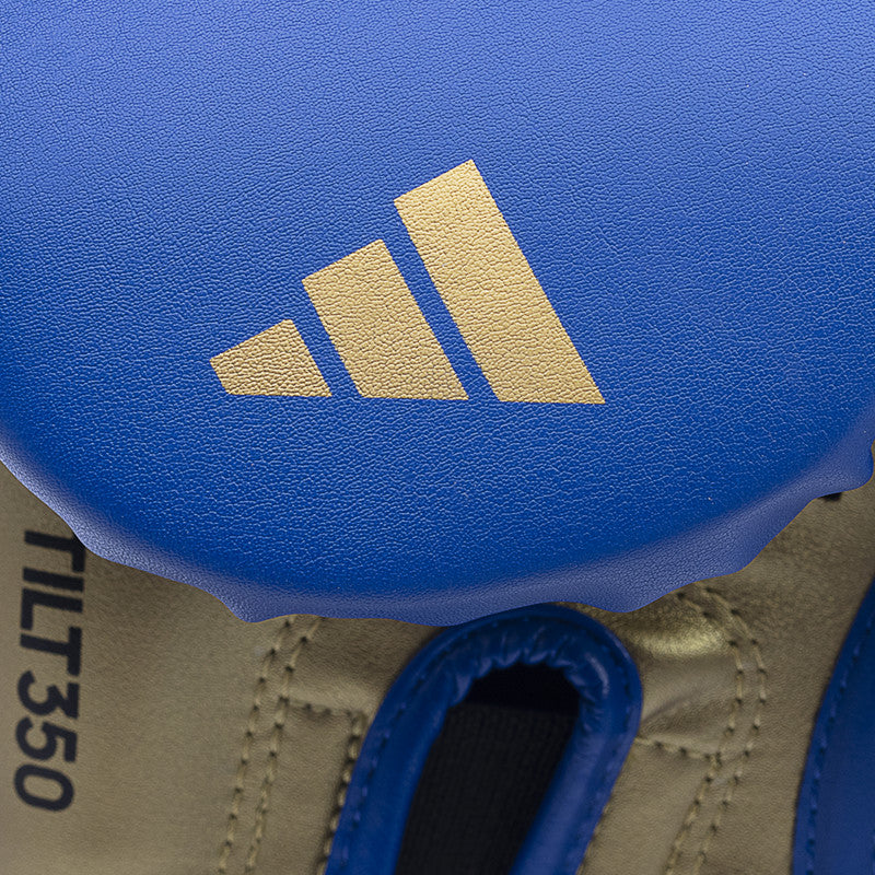 Close-up of a blue and gold logo on Tilt 350 PRO training gloves.