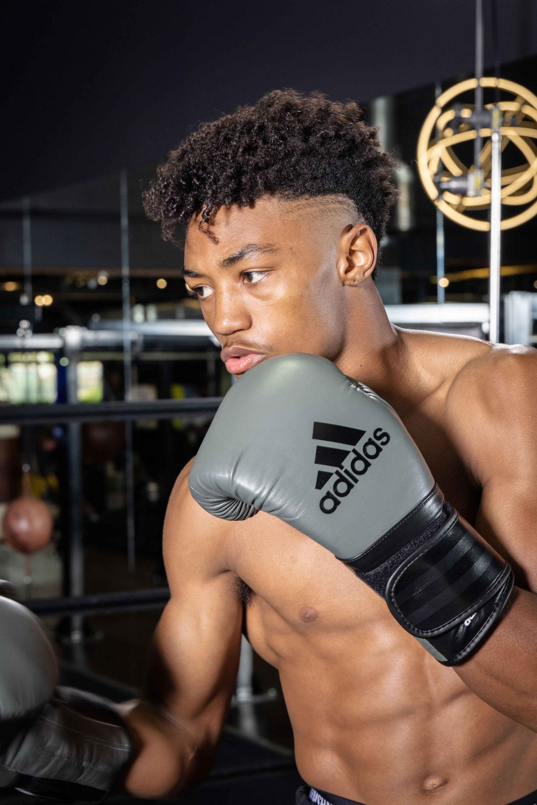 Man wearing boxing gloves, part of the adiSPEED 501 PRO series.